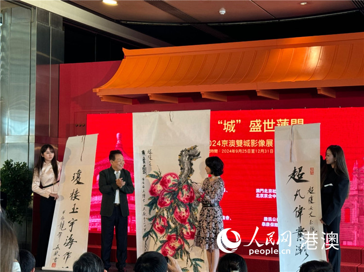 圖為吳歡向澳門(mén)北京社團(tuán)總會(huì)會(huì)長(zhǎng)何超瓊捐贈(zèng)作品。（本報(bào)記者富子梅攝）