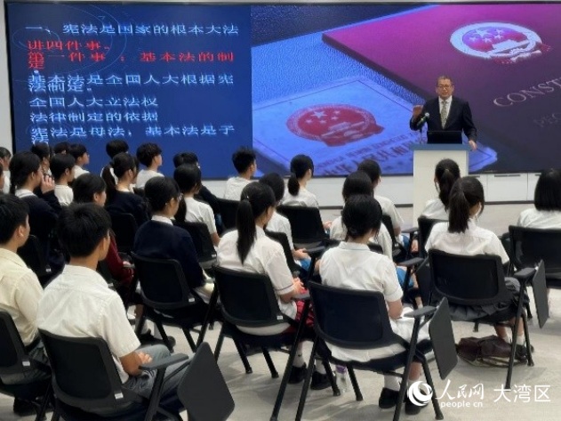 澳門大學(xué)法學(xué)院教授駱偉建在青少年普法講座上為中學(xué)生講解憲法和澳門基本法。人民網(wǎng)記者 富子梅攝
