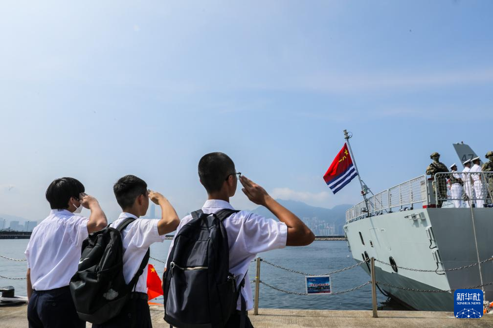 7月7日，湛江艦即將駛離昂船洲軍營(yíng)碼頭，三名香港福建中學(xué)的學(xué)生向懸掛在艦尾的海軍軍旗敬禮。新華社發(fā)（馮麗 攝）
